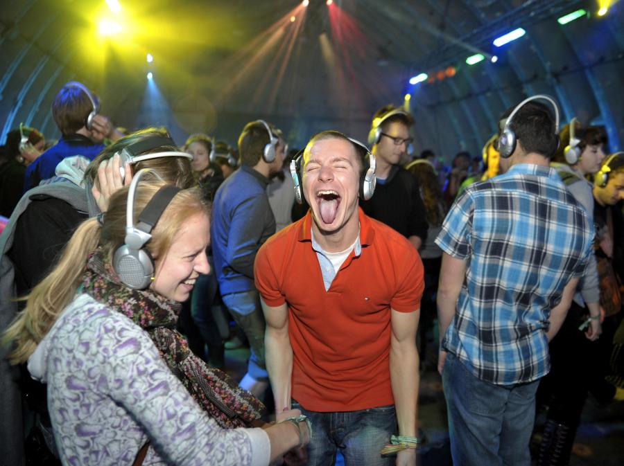 Zabawa w hangarze Silent Disco przy muzyce, którą słychać tylko przez słuchawki